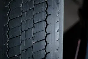 Detailed close-up of a worn tire tread showcasing grooves and patterns.