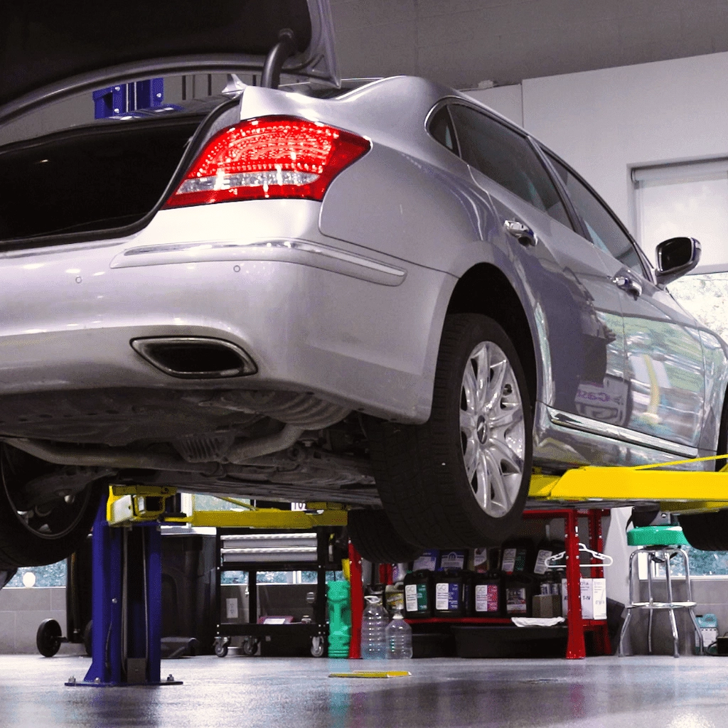 gray car lifted off of the ground with trunk open
