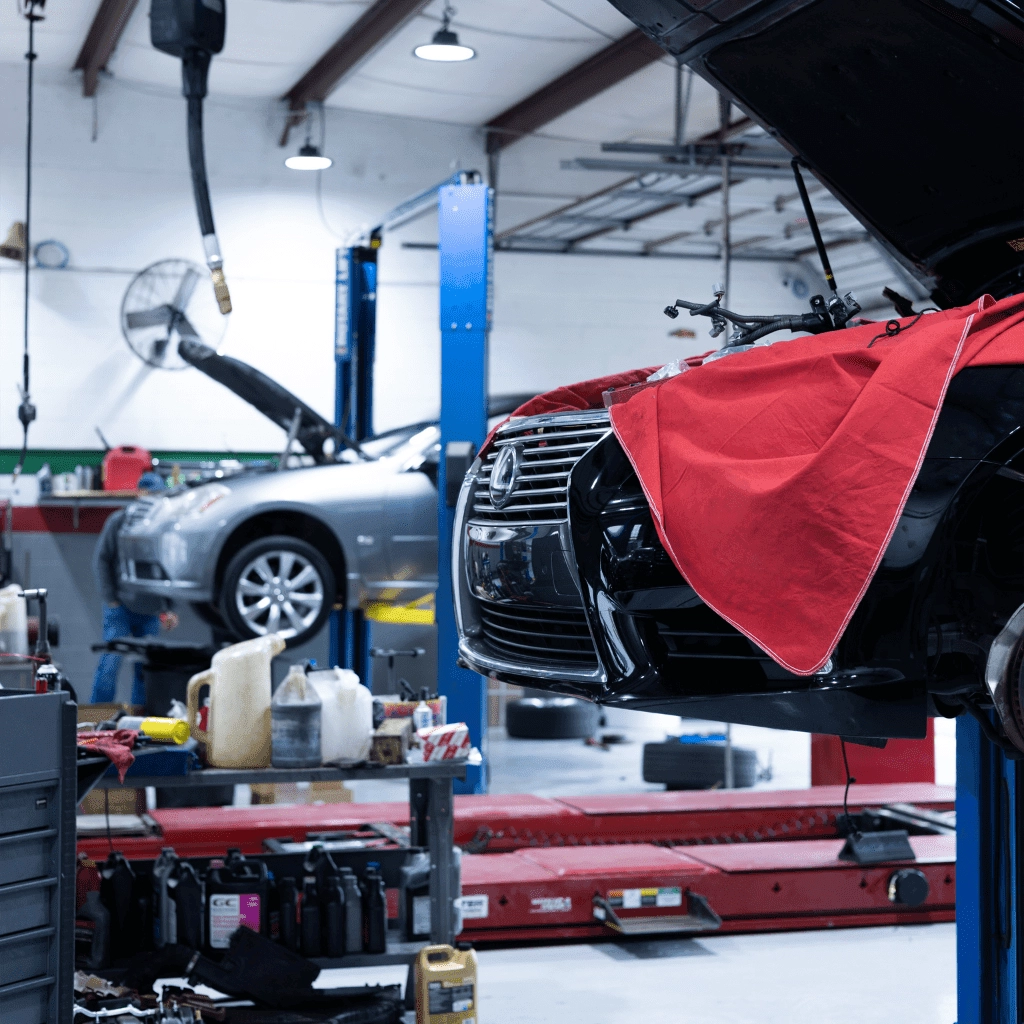 two vehicles lifted in a repair shop